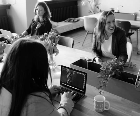 Three people at a conference table in the office.